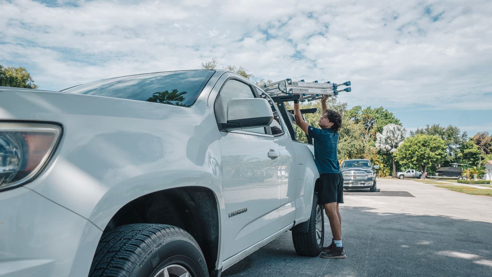 Coast technician taking the ladder down from the truck at a Miami job